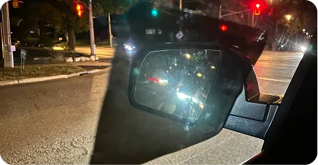 Side mirror at night with headlight glare softened